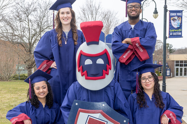 Soon-to-be Eastern graduates pose for a photo with Willi the Warrior. 