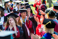 Joelle Matthews smiles as faculty clap for her and other graduates at SUNY Potsdam's Commencement.