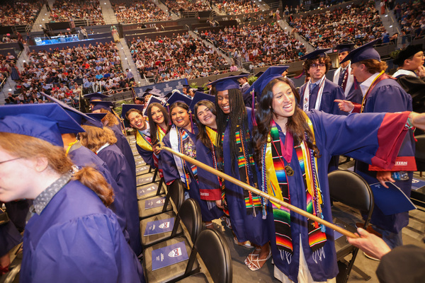 Happy graduates and families fill the arena. 