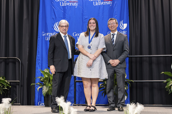 Paul Alberto, Lillian Meeker and Jerry Wu pose for a photo on stage at the college's 2026 Scholars Recognition Luncheon.