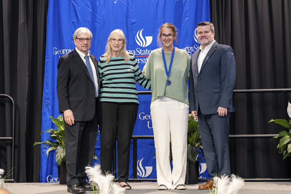 Paul Alberto, Ann Parkman, Emily Epp and Brendan Calandra pose for a photo on stage at the college's 2026 Scholars Recognition Luncheon.