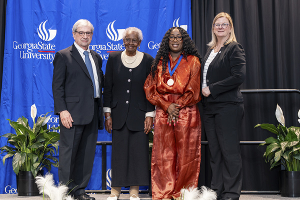 Paul Alberto, Vivian Street, Gracieuse Jeanpierre-Foy and Reneé Schwartz pose for a photo on stage at the 2026 Scholars Recognition Luncheon.