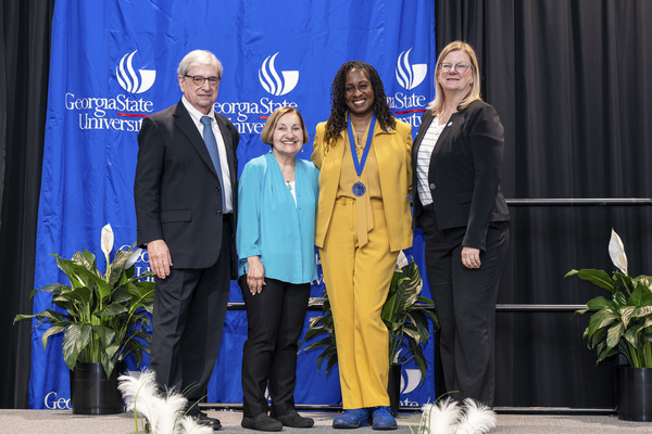 Paul Alberto, Beverly Armento, Romonda Middlebrooks-Jefferson and Reneé Schwartz pose for a photo on stage at the 2026 Scholars Recognition Luncheon.