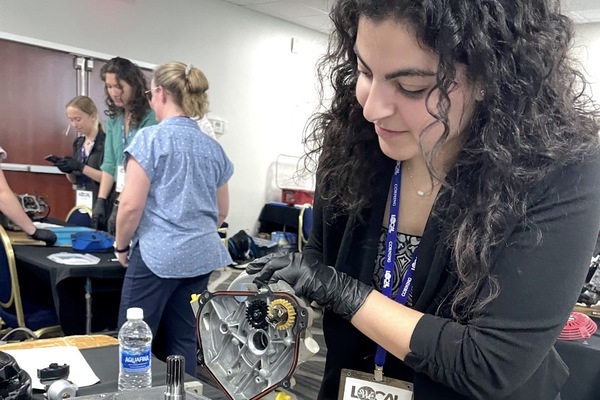 Martina Tatalias works with a lawn mower engine during a workshop at a Society of Women Engineers conference. 