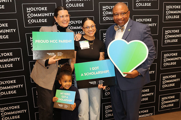 HCC student Araba Murray-Adoboe of Amherst celebrates her scholarship award with her family and President George Timmons.