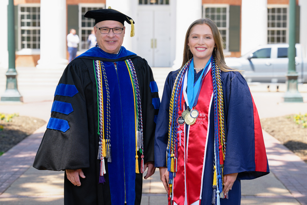 Image of Provost Noel Wilkin and class marshal Mary Catherine Drane in graduation regalia.