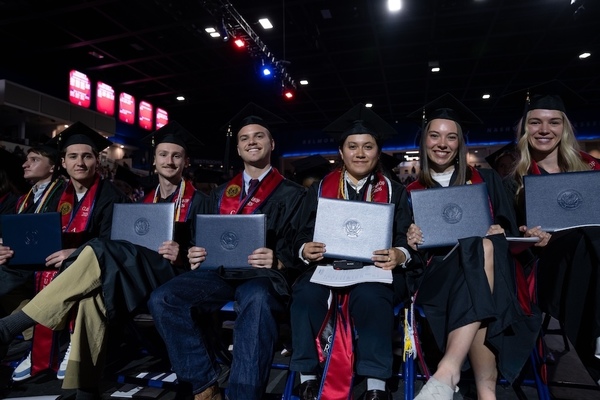 Students at graduation sitting with diplomas