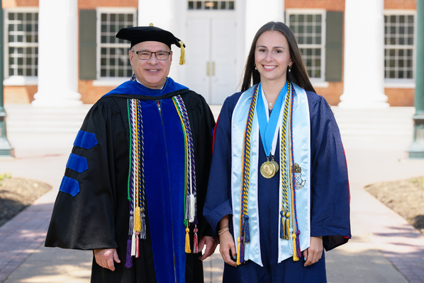 Image of Provost Noel Wilkin and banner bearer Callista Rose Hull in graduation regalia.