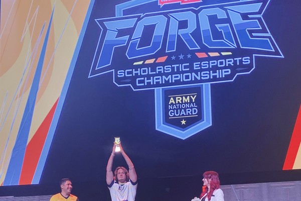 Jonah Kyle, center, a member of Trine University's Overwatch team, accepts the Forge Scholastic Esports Championship 2026 Uncommon Player Award at the first ECAC National Founders Invitational.