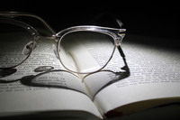 A photograph of glasses sitting on top of an open book.