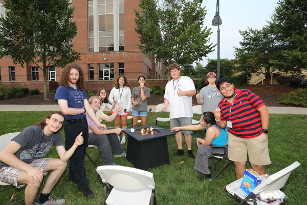 Previous program participants socialize over s'mores.