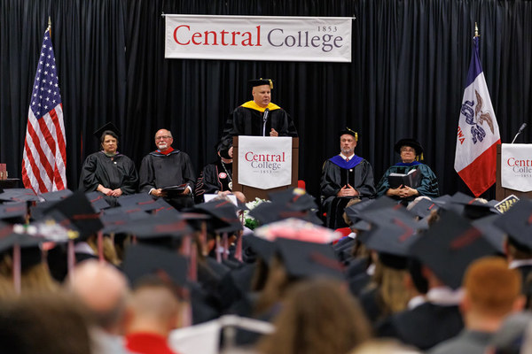 Commencement speaker at podium addressing students. 