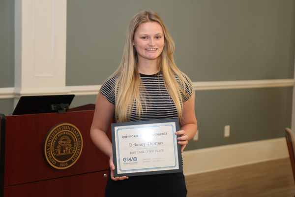 Student poses with award certificate