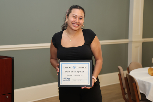 Student poses with award certificate