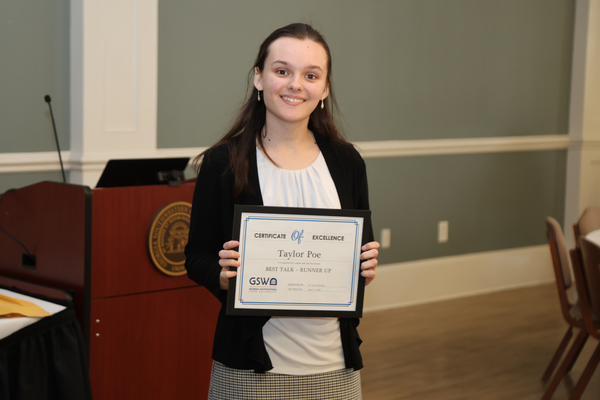 Student poses with award certificate