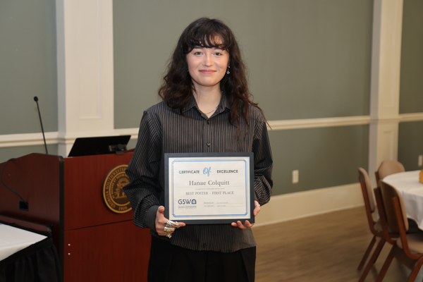 Student poses with award certificate