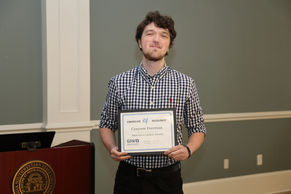 Student poses with award certificate 