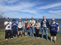 Students and a professor pose with their binoculars while on a field trip to the Derby Hill Bird Observatory.