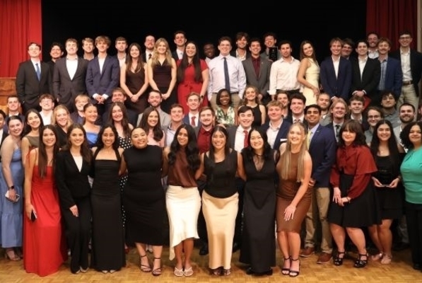 students are dressed up and posing together on a stage during the banquet
