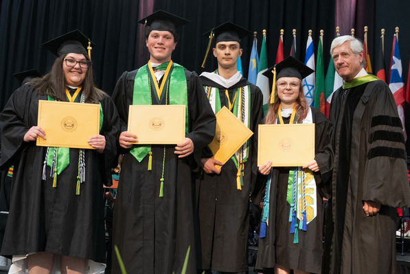 Winners of the Argonaut Award at graduation holding their certificates and smiling for a picture