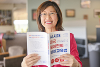 Professor Eunjyu Yu holds a copy of her new book, Revolutions in English Classrooms in the AI Era in SUNY Canton's Southworth Library. 