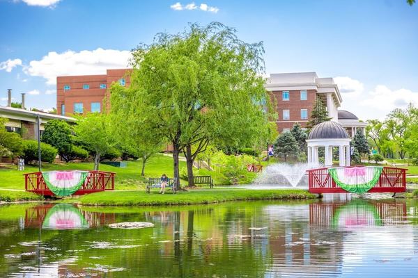 A springtime image of Sarah's Glen at Shenandoah University, featuring the fountains, gazebo and red bridges.