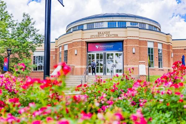 Shenandoah University's Brandt Student Center with pink flowers in the foreground.