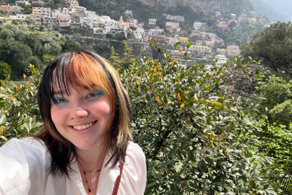 student takes selfie with Italian landscape in the background