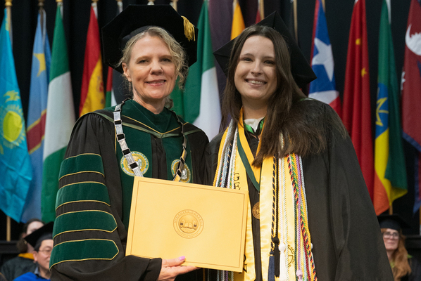 Winner of The Edith Farr Ridington Writing Award smiling for a picture with Julia Jasken, McDaniel college president.