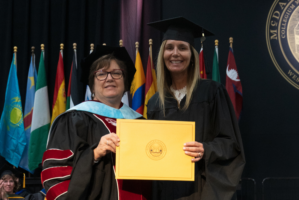 Recipient of The Joan Develin Coley Award for Excellence in Education holding her certificate and smiling for a photo with Vickie Mazer. 