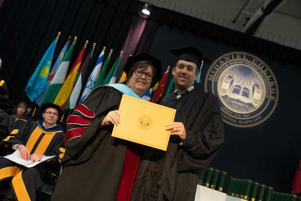 Recipient of The B. Jill Brooks Hodge Professional Development Award holding his certificate and smiling for a photo with Vickie Mazer