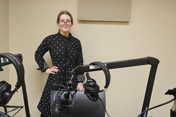 MTSU student standing in podcast studio in the Walker Library on campus.