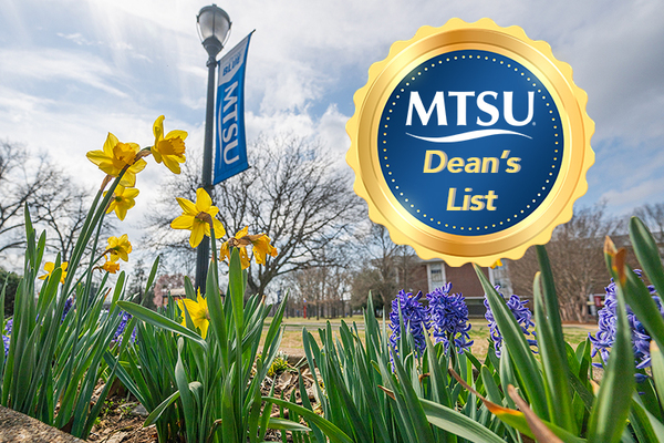 MTSU campus scene with yellow and purple flowers in foreground and MTSU poll banner and brick building in background.
