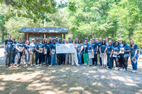 Group photo of approximately 35 standing presenting a ceremonial donation check for the college’s SNAC Pantry.