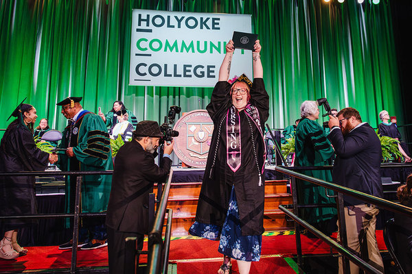 Student holding graduation diploma over her head