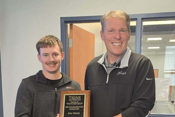 Zakeri Pica, left, a Trine University software engineering major from Fremont, Indiana, presents Eric Wirick, a teacher at Fremont High School, with the Outstanding High School Teaching Award from the university's Department of Electrical and Computer Engineering.