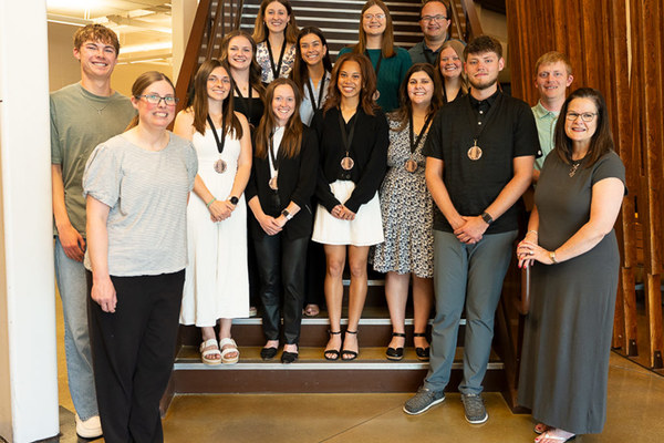 The final gathering of Marburger Leadership Institute fellows featured a presentation of medallions. Standing on left side of stairs: Melissa McAninch, associate professor of education, education chair and Marburger Leadership Institute co-director, and Jack Every ’28, medallion designer. Standing on right side of stairs: Ajay Six ’27, Julianne Taylor, senior lecturer of education and Marburger Leadership Institute co-director, and Seth Marburger ’16 and son of Dan and Elizabeth Marburger. On stairs: Row 1 – Jillian Fairbanks ’27, Rylee Dunkin ’27, Jasmyn Williams ’26, Georgia Matthews ’26. Row 2 – Lydia Fisher ’27, Emma Murphy ’27, Taylor Sniezek ’26. Row 3 – Madeline MacGregor ’26, Brianna VanGroll ’28, Samuel Vis ’27.
