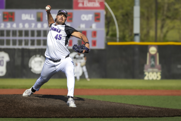 A college pitcher delivering a pitch.