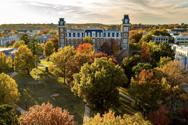 aerial view of Old Main in the fall with leaves changing on trees with a nice sunset
