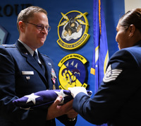 Air Guard officer gets flag during retirement ceremony.