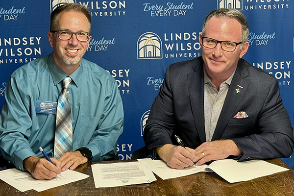 Lindsey Wilson University Director of Enrollment Ryan Vitatoe, left, and Sobrius CEO Nelson Smith sign the Lindsey Wilson University-Sobrius Scholarship, which will be available to Sobrius employees and their family members who enroll in Lindsey Wilson academic programs.