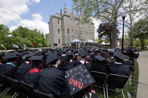 Ohio Wesleyan graduates sit watching their outdoor commencement ceremony. 