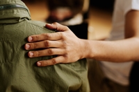 Hand on shoulder, suggesting victim support services