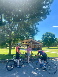 Cyclists chat after a ride, resting their bikes near the Marshall Park bandshell.
