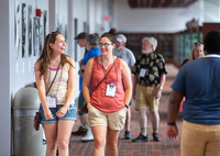 Reunion attendees smile and chat while walking through the Timerman Hall lobby.