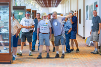 Alumni smile and point while touring the rock, mineral and fossil exhibits in SUNY Potsdam's Timerman Hall.