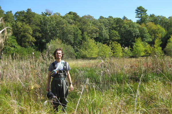 College student standing in a field of tall grass
