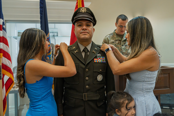 New York Army National Guard Chief Warrant Officer 4 Carlos Perez, has his new rank pinned on by his wife and daughter during a ceremony held at Camp Smith Training Site, near Peekskill on June 25, 2026. Perez, who serves as the warrant officer strength maintenance manager for the New York Army National Guard's Recruiting and Retention Battalion is a veteran of the wars in Iraq and Afghanistan. (U.S. Army National Guard photo by Sebastian Rothwyn)