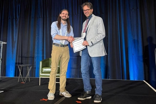 students stands on stage accepting award