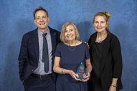 The Felitto family stands with a SUNY Canton Hall of Fame award in front of a blue backdrop. 